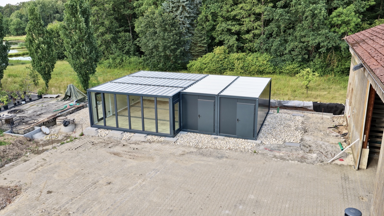 Luftaufnahme der anthrazit Glas-Mehrfachanlage auf Schotterfundament