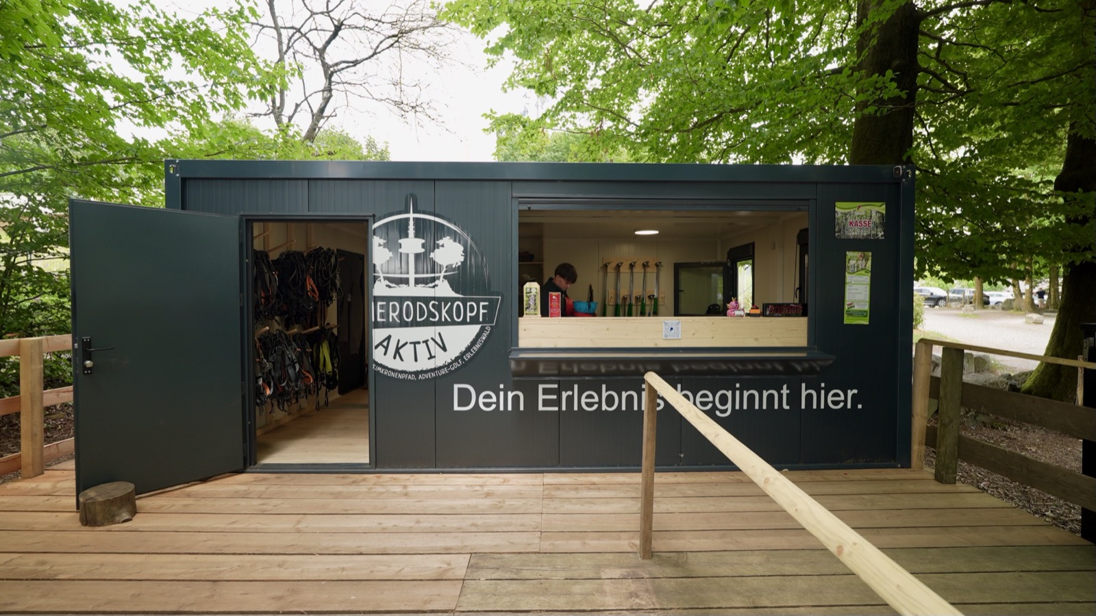Hoherodskopf Aktiv: anthrazit Verkaufscontainer mit Servicefenster und Klettergurten im Wald