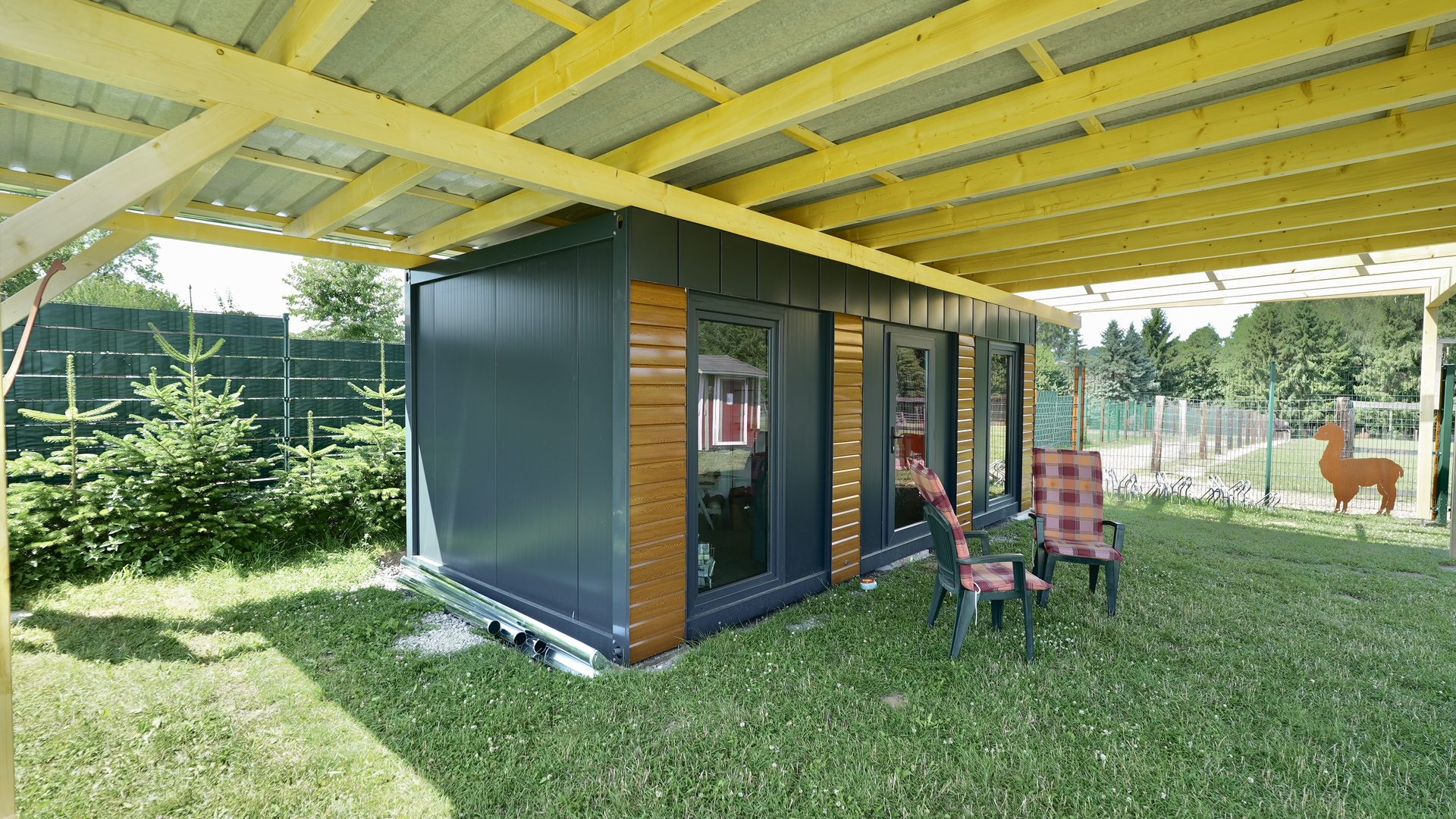 Anthrazit-Modul mit Holz und Glas unter Vordach